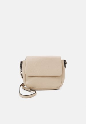 Jasnobeżowa skórzana torebka na ramię z teksturowanym wykończeniem, z klapką i regulowanym paskiem. Kompaktowy, zaokrąglony kształt z minimalną ilością elementów metalowych.