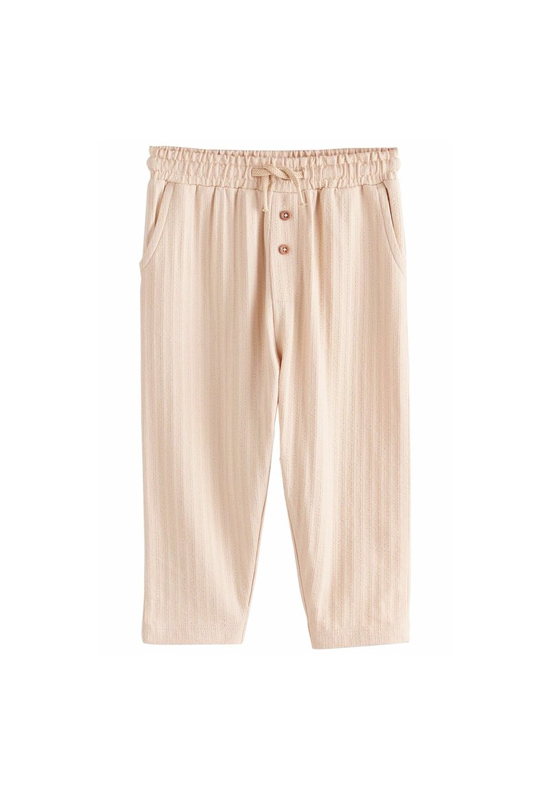 Pantalon beige clair texturé avec une taille élastique, cordon de serrage, poches avant et trois boutons décoratifs. Motif rayé présent.