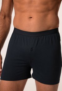 Boxer da uomo blu scuro realizzati in morbido cotone, con elastico in vita e logo in rilievo, dotati di bottone anteriore per la chiusura.
