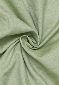 Tessuto verde chiaro, con texture e un sottile motivo a righe, che mostra una superficie liscia e morbida, leggermente stropicciata in un arrangiamento a spirale.