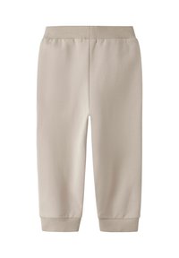 Pantalones de chándal de algodón beige con cintura elástica y puños acanalados, que presentan una textura suave y un corte cómodo. Sin patrones o acentos visibles.