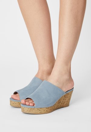 Blue suede wedge sandals with an open toe design and cork platform. Smooth texture with a solid color, featuring stitched detailing along the edges.