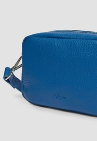 Blauwe leren tas met een gestructureerde afwerking, rechthoekige vorm, bovenrits en een zilveren sluiting bevestigd aan een korte schouderband.