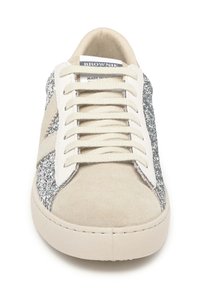 Zapatillas deportivas de ante beige con detalles de purpurina plateada y cordones blancos. Textura suave, puntera redondeada y branding sutil en la lengüeta.