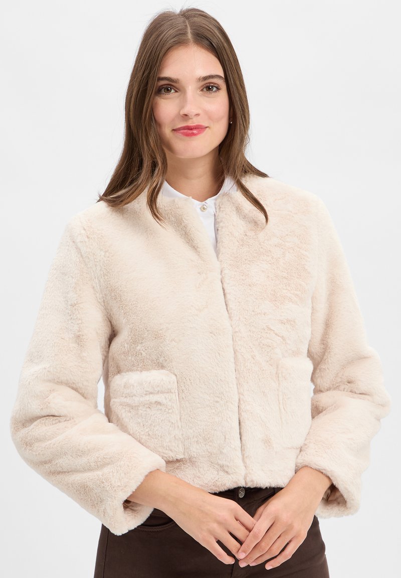 Korte nepbontjas in lichtbeige, met zijzakken, een ronde hals en brede mouwen voor een zachte, gestructureerde uitstraling.