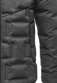 Gray puffer jacket with quilted sections and a smooth texture. Features vertical and horizontal stitching for insulation and style.
