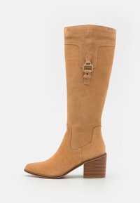 Knee-high tan suede boots with a square toe, textured heel, and a decorative strap with buckle detail. Featured stitching accents.