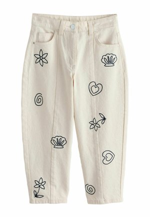 Hose in Cremefarben mit schwarzen, aufgestickten Mustern, darunter Blumen, Herzen, Muscheln und Spiralen auf den Vorderbeinen und Taschen.