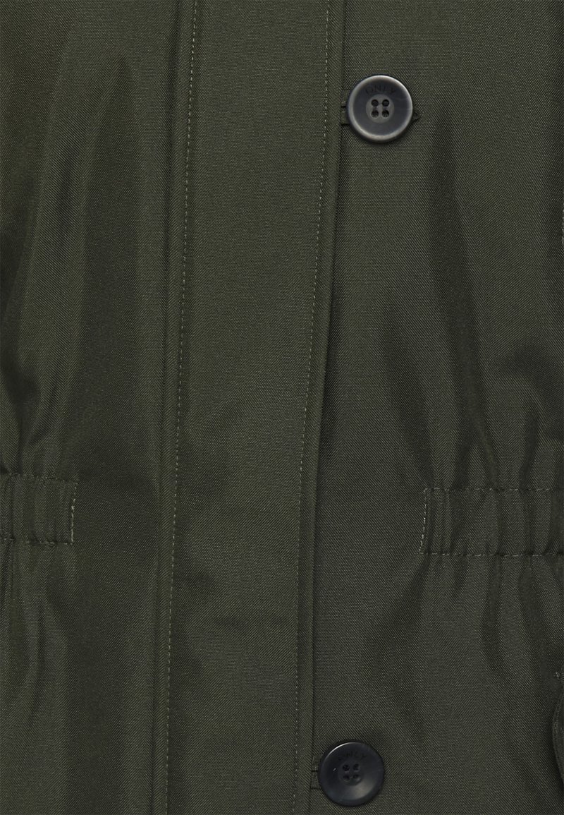 Dunkelgrüne Jacke aus strukturiertem Stoff, mit einer Reihe schwarzer Knöpfe und elastischem Taillendetail für eine figurschmeichelnde Passform.