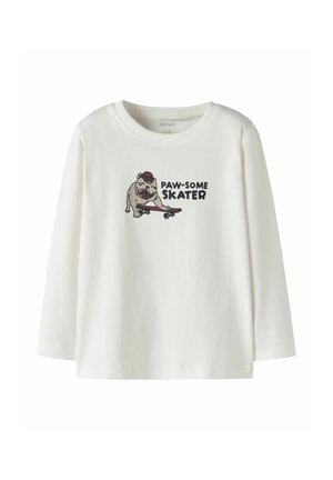 Cămașă crem cu mânecă lungă din bumbac, prezentând un grafic cu un câine pe o skimboard cu textul "PAW-SOME SKATER".