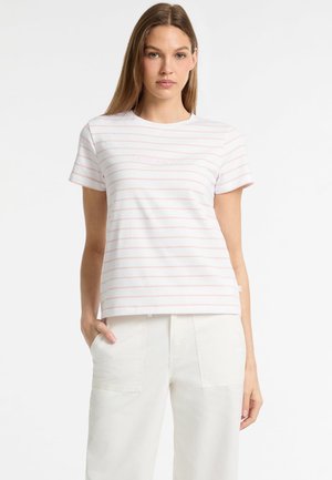 Camiseta blanca con rayas horizontales rosas, de manga corta, con cuello redondo y logo bordado en el pecho, combinada con pantalones de color claro.