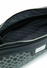 Borsa nera con cerniera, con motivo circolare, esterno in pelle liscia, interno in tessuto con design a righe e dettagli del logo.
