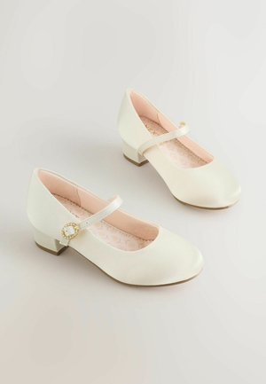 Pantofi Mary Jane din piele ecologică albă, cu vârf rotund, toc mic și detaliu de cataramă metalică aurie pe bretea. Branț roz pal.