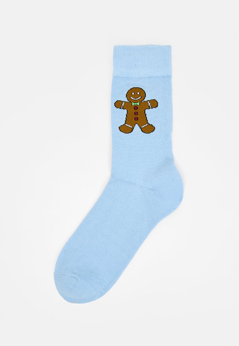 Lichtblauwe katoenen sok met een geborduurd ontwerp van een gingerbread mannetje met een glimlachend gezicht, een groene strik en kleurrijke knopen.