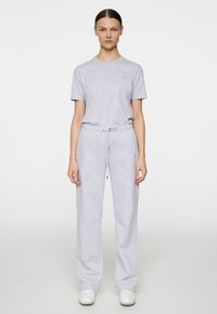 Grijze katoenen T-shirt met korte mouwen en een ronde hals, gecombineerd met grijze joggingbroek met een elastische tailleband en een trekkoord.