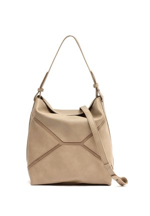 Bež usnjena torbica čez ramo z nastavljivim trakom in všitim geometričnim vzorcem, mehka ohlapna struktura, na belem ozadju.