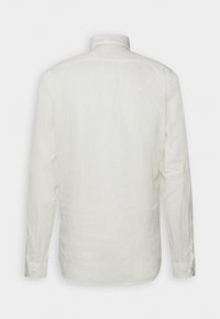 Camisa blanca de manga larga de lino, con cuello estándar, puños con botones y una textura suave con un diseño simple y limpio.