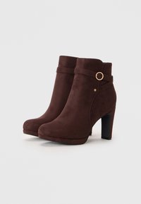 Brune semskede ankelstøvler med rund tå, høje hæle og dekorativ rem med en gyldent spænde. Glat tekstur og minimalistisk design.