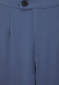 Jasnoniebieskie spodnie wykonane z gładkiego materiału, z pojedynczym czarnym zapięciem na guzik oraz ostrymi zakładkami na przodzie dla eleganckiego wyglądu.