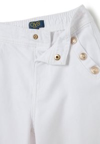 Witte kinderbroek met een rekbare tailleband, voorzien van gouden knoopdetails aan de voorkant en een textuurstof met subtiele diagonale lijnen.