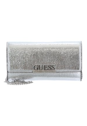 Pochette argentée métallisée texturée avec logo GUESS et détail en strass, équipée d'une bandoulière chaîne argentée.