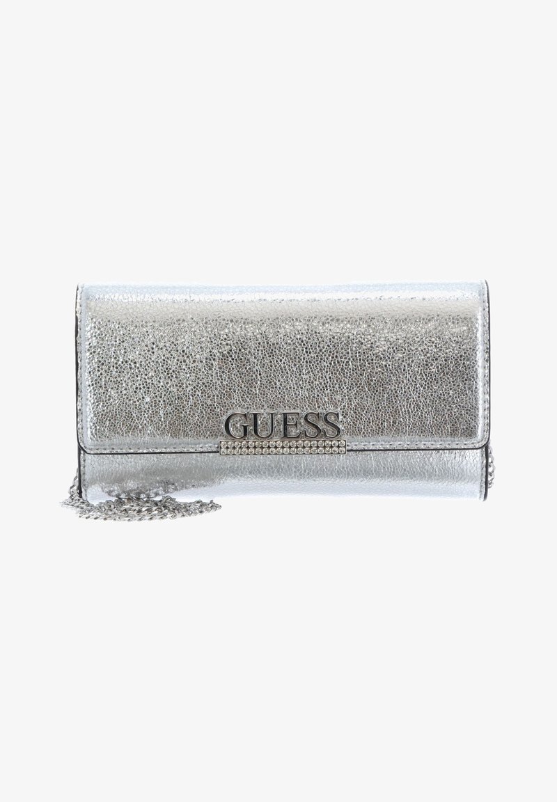 Pochette argentée métallisée texturée avec logo GUESS et détail en strass, équipée d'une bandoulière chaîne argentée.