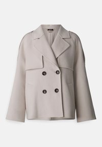 Cappotto doppiopetto in misto lana color beige chiaro, con rever a punta, due ampie tasche frontali e chiusura con bottoni. Sottolineato da maniche ampie.