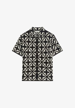 Chemise à manches courtes boutonnée avec motif géométrique losange noir et blanc et col.