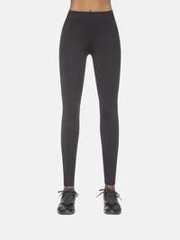 Czarne legginsy z wysokim stanem, wykonane z elastycznego, odprowadzającego wilgoć materiału. Gładka faktura z dopasowanym krojem, w połączeniu z czarnymi butami sportowymi.