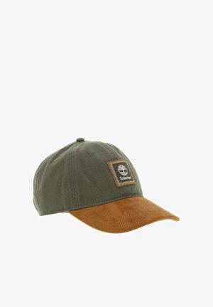 Casquette de baseball en coton vert avec une visière en daim marron. Présente un patch carré avec un logo sur le devant. Conception à six panneaux avec des œillets.