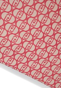 Tessuto stampato con disegni circolari interconnessi in rosso e beige. Il materiale ha una texture liscia con una stampa uniforme.