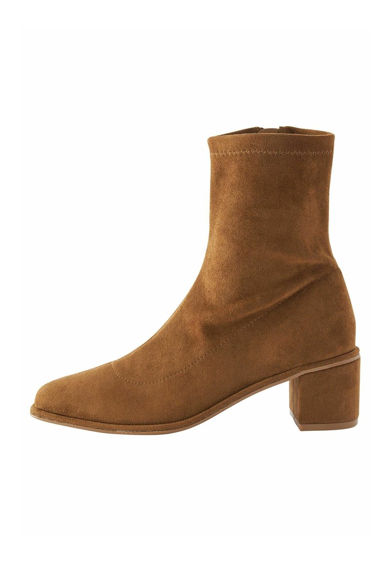 Botă de gleznă din suede maro, cu vârf pătrat și toc bloc de înălțime medie. Design elegant, cu cusături minime și o textură netedă.
