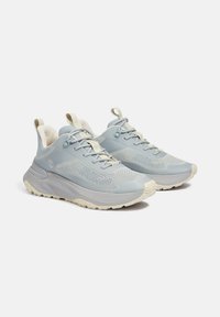 Hellblaue Sportschuhe mit einem strukturierten Mesh-Obermaterial, cremig-weißen Akzenten, dicker Polsterung und einer robusten Sohle für besseren Halt.