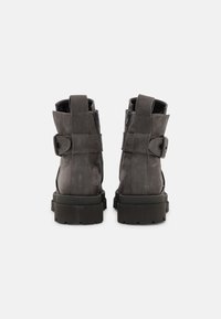 Šedé kožené kotníkové boty s texturovaným povrchem, s kulatou špičkou, bočním zipem a robustní gumovou podrážkou. Detaily s nastavitelným páskem.