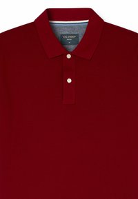 Rode polo shirt gemaakt van zacht stof met een klassieke kraag, voorzien van drie witte knopen en een blauwe accent op de binnenkraag.