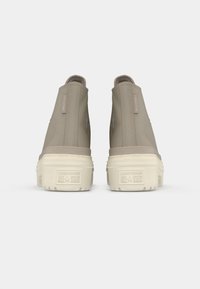 Beige High-Top-Sneaker mit einem glatten Obermaterial, texturiertem Außensohle und Logoprint hinten. Flache Sohlen und elastische Seitenpanels.