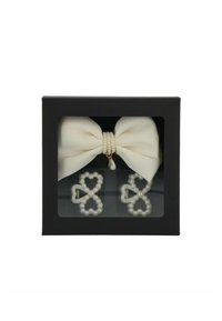 Elastico per capelli con perle e orecchini a forma di cuore in una scatola regalo nera. L'elastico presenta un fiocco di stoffa crema con decorazioni di perle.