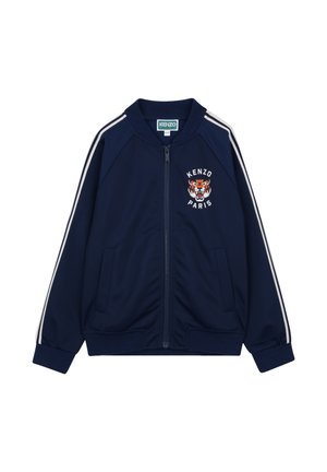 Giacca con cerniera blu navy con strisce bianche sulle maniche, polsini a coste e logo tigre ricamato con la scritta "KENZO PARIS" sul petto.