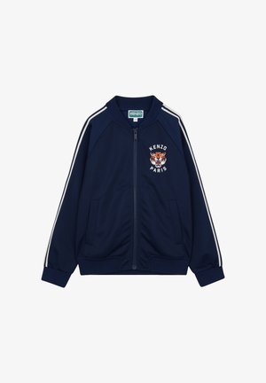 Giacca con cerniera blu navy con strisce bianche sulle maniche, polsini a coste e logo tigre ricamato con la scritta "KENZO PARIS" sul petto.