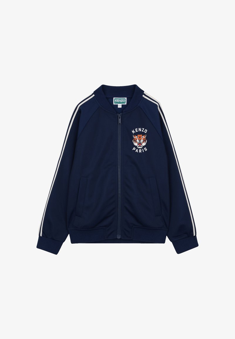 Veste zippée bleu marine avec des rayures blanches sur les manches, des poignets côtelés et un logo tigre brodé avec l'inscription "KENZO PARIS" sur la poitrine.