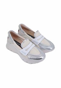 Scarpe bianche slip-on con accenti metallici argento, tessuto testurizzato e una spessa suola bianca. Presentano fasce elastiche e un interno imbottito.