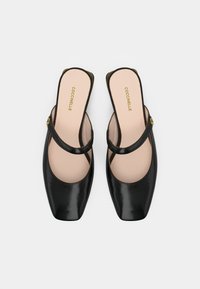 Μαύρα δερμάτινα παπούτσια με λουράκι στη φτέρνα, τετράγωνη μύτη, λεία υφή και λεπτό λουράκι. Η εσωτερική σόλα φέρει διακριτική χρυσή σήμανση.