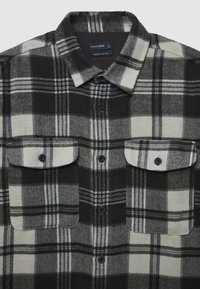 Kariertes Flanellhemd in Schwarz, Weiß und Grau. Verfügt über zwei Brusttaschen mit Knöpfen, klassischen Kragen und sichtbare Nähte. Reguläre Passform.