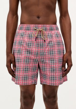 Shorts de bain à carreaux en gris et rose avec une taille élastique et un cordon de serrage beige. Le matériau est léger et lisse.