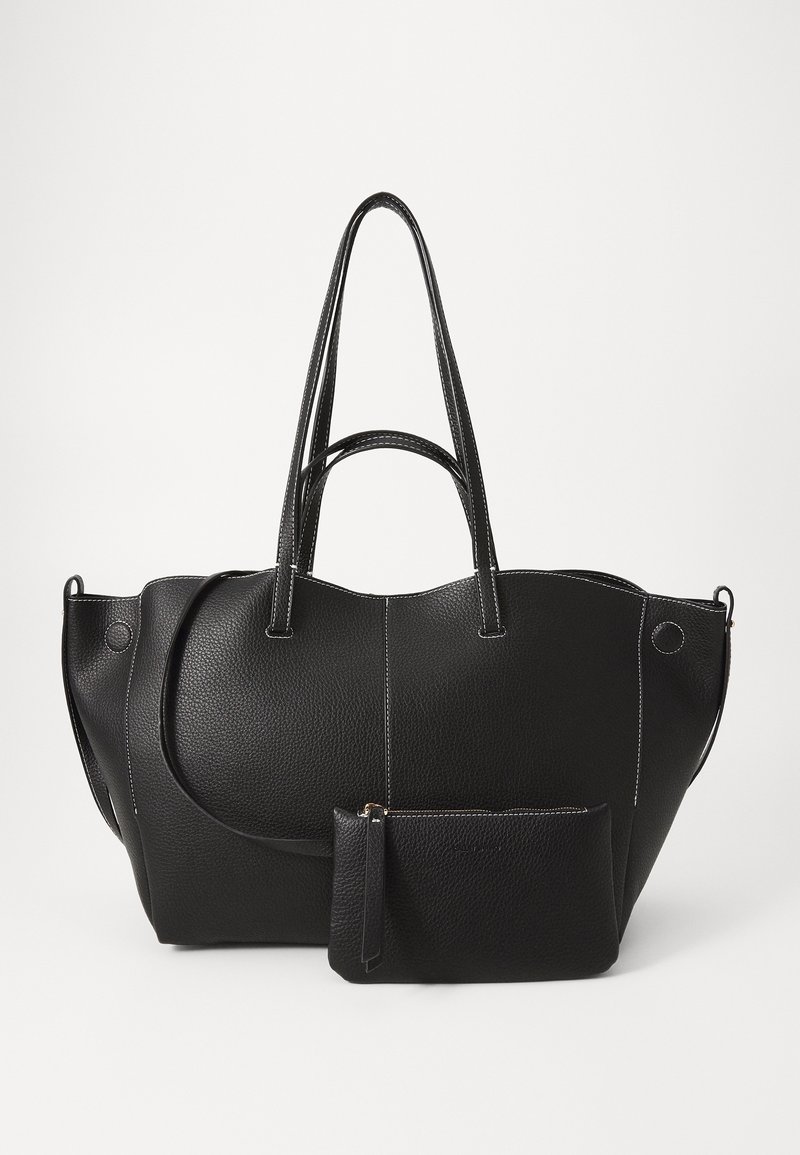 Sac cabas en cuir noir avec surface texturée, design incurvé, double anses et coutures blanches. Comprend une petite pochette zippée assortie.