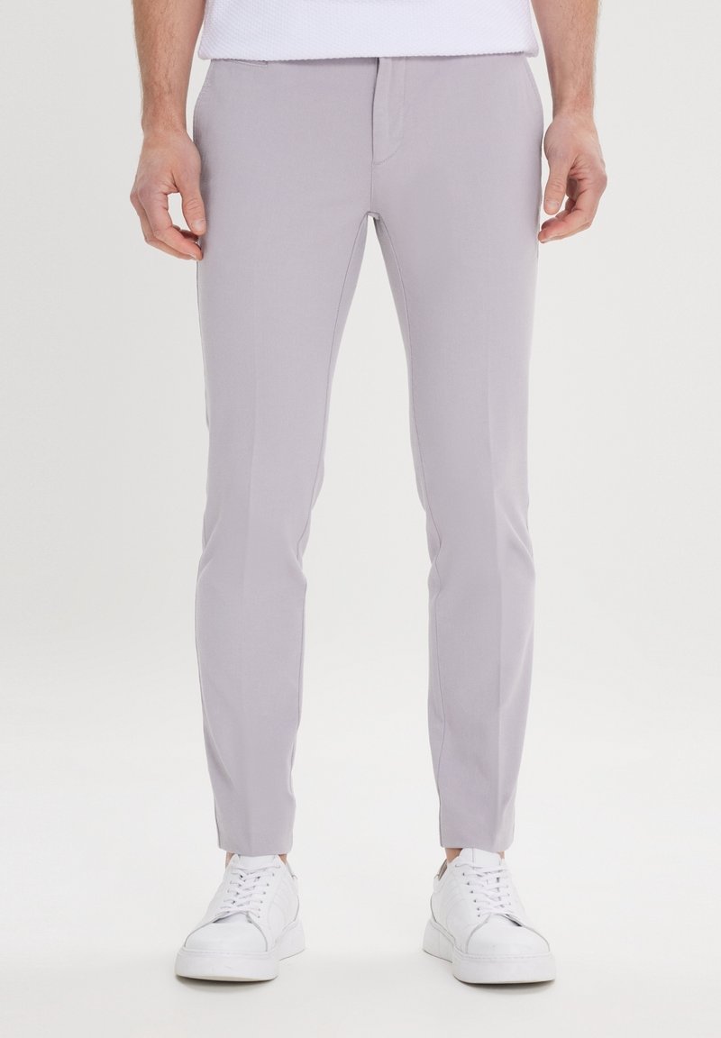 Light gray slim-fit pants made of textured fabric, featuring front pockets and a smooth waistband, paired with white sneakers.