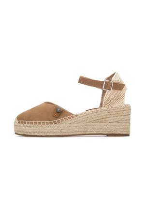 Espadrille de ante marrón con cuña de yute trenzado, correa en el tobillo y panel posterior de malla. Presenta un adorno decorativo con botón.