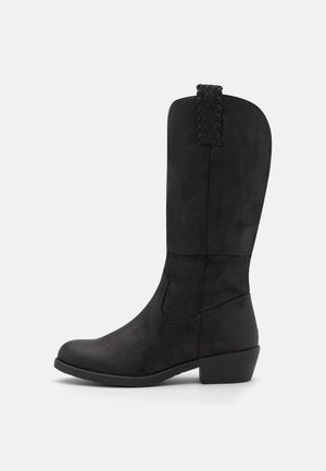 Botte noire mi-mollet avec talon bloc bas et languette tissée, texture lisse et bout arrondi, vue de côté gauche sur fond blanc.