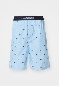 Light blue shorts with a navy waistband, featuring a repeated small navy crocodile pattern. Made from a breathable fabric.