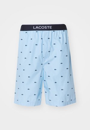 Shorts bleu clair avec une taille navy, présentant un motif de petits crocodiles navy répétés. Fabriqué à partir d'un tissu respirant.